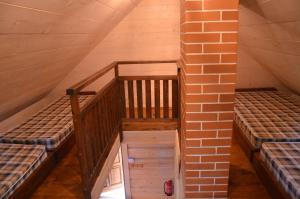 an attic with two bunk beds and a brick wall at Tõrvaaugu Holiday Homes in Mägede