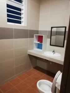 y baño con lavabo, aseo y espejo. en Sakura Homestay 4 bedrooms 14pax- Eaton Hills Padang Kerbau Miri en Miri