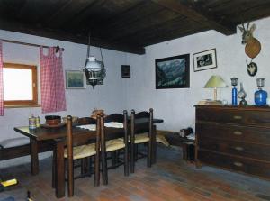 a dining room with a table and chairs in a room at Architect`s Cottage - serenity and greenery in the highlands in Soča