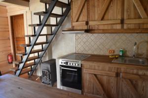 a kitchen with a stove and a spiral staircase at Tõrvaaugu Holiday Homes in Mägede