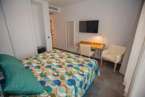 a bedroom with a bed and a table and a desk at Hotel Adiafa in Barbate