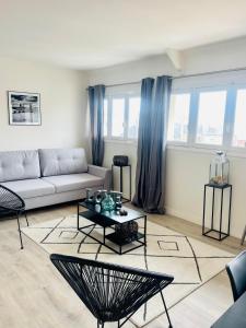 a living room with a couch and a table at Deauville Serenity - Spacieux & Chic à Place Morny in Deauville