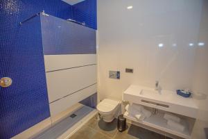 a bathroom with a shower and a toilet and a sink at Hotel Adiafa in Barbate