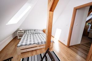 a small bedroom with a bed in a attic at Apartament Pastorówka in Pisz