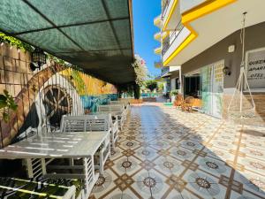 a patio with a table and chairs on a tiled floor at Alanya Queen Apart Otel in Alanya