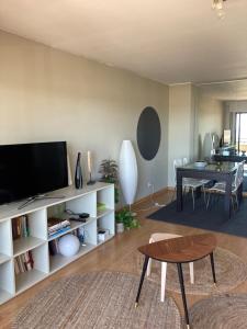 uma sala de estar com uma televisão e uma mesa em Oporto beach apartment em Matosinhos