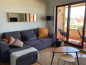 a living room with a blue couch and a table at Oporto beach apartment in Matosinhos