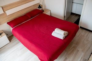 a red bed with a towel on top of it at Casa Po in Granada
