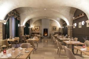 a restaurant with tables and chairs and a fireplace at Domaine de Saulon in Saulon-la-Rue