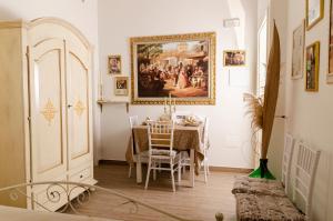 un comedor con una mesa y una pintura en la pared en [ApuliaLux] Salento d'incanto - Suites con Piscine Idromassaggio, en Taurisano