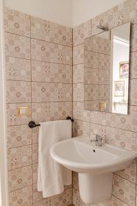 y baño con lavabo y espejo. en [ApuliaLux] Salento d'incanto - Suites con Piscine Idromassaggio, en Taurisano