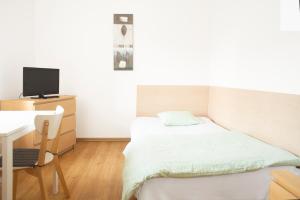 niewielka sypialnia z łóżkiem i biurkiem w obiekcie Willa Na Nehringa w Poznaniu