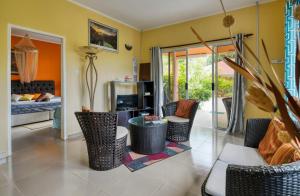 uma sala de estar com cadeiras e um quarto com uma cama em Alha Villa em Baie Lazare Mahé