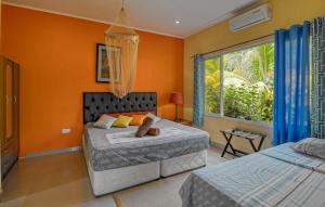 sypialnia z 2 łóżkami i oknem w obiekcie Alha Villa w Baie Lazare Mahé