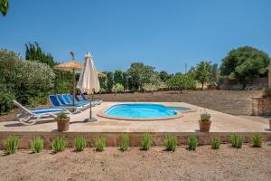 einen Pool mit 2 Liegestühlen und einem Sonnenschirm in der Unterkunft Casa Can Pauma in Ca's Concos des Cavaller