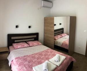 a bedroom with two beds and a large mirror at Apartmani Cupara in Tivat