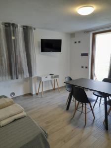 a living room with a bed and a table with chairs at Il Poggio Degli Olivi in Serò