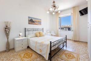 una camera bianca con un letto e una finestra di Pintadera B&B a Cagliari