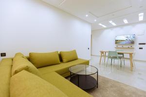 a living room with a yellow couch and a table at EL NIDO ALHOCEIMA in Al Hoceïma