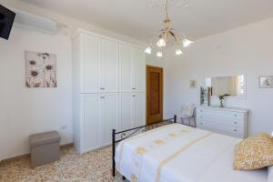 una camera bianca con letto e cassettiera di Pintadera B&B a Cagliari