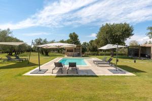 een zwembad met stoelen en parasols naast een veld bij Le Querce exclusive c house in Viterbo
