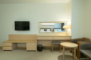 首爾的住宿－首爾G地酒店，酒店客房配有书桌和电视。