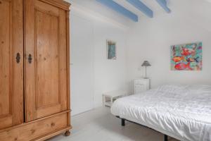 アルゾンにあるMaison pour 5 - Grand jardin - 700m de la plageのベッドルーム1室(ベッドの横に大きな木製キャビネット付)