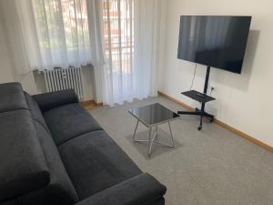 uma sala de estar com um sofá e uma televisão de ecrã plano em Appartamento Laura em Merano