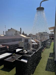 a rooftop patio with black furniture and a light at Hotel Plaza in Seville