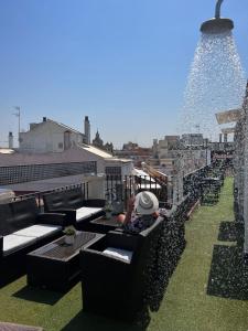 a person sitting on top of a roof at Hotel Plaza in Seville