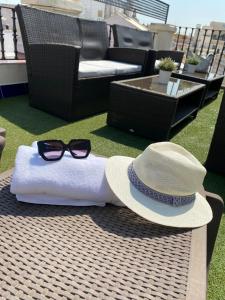 Un sombrero y gafas de sol están sentados en una mesa. en Hotel Plaza, en Sevilla