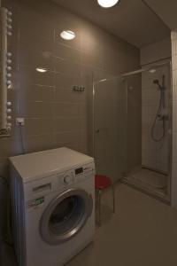 a washing machine in a bathroom with a shower at Atrium Luksusowe Apartamenty in Sarbinowo