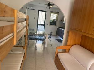 une chambre avec des lits superposés et une salle à manger avec une table dans l'établissement Le Ville 1 Costa Saracena, à Agnone Bagni