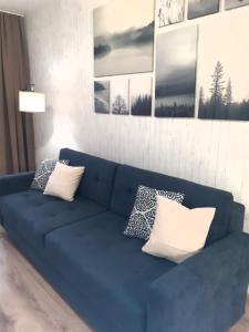 un sofá azul en una sala de estar con almohadas en Apartament Waldi en Kołobrzeg