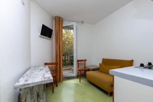 eine Küche und ein Wohnzimmer mit einer Couch und einem Tisch in der Unterkunft Village Vacances Le Junka in Vieux-Boucau-les-Bains