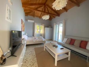 a living room with a couch and a tv at Sea House Kitries in Kitriaí