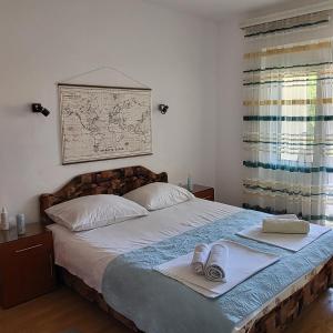 a bedroom with a bed with two towels on it at Apartmani Mia Sorajic in Petrovac na Moru +38 photos