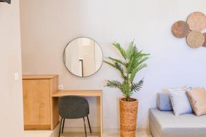 a living room with a mirror and a chair at Eleftherias Suites - Near Beach Apartments in Marathi