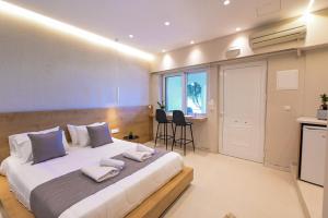 a bedroom with a large bed with towels on it at Eleftherias Suites - Near Beach Apartments in Marathi