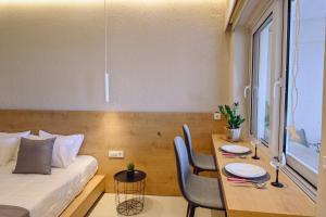 a room with a bed and a table with chairs at Eleftherias Suites - Near Beach Apartments in Marathi