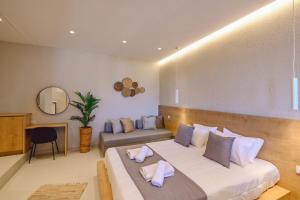 a bedroom with a large bed and a couch at Eleftherias Suites - Near Beach Apartments in Marathi