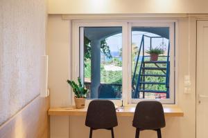 two chairs sitting at a desk in front of a window at Eleftherias Suites - Near Beach Apartments in Marathi