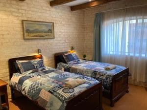 a bedroom with two beds and a window at Kite View 2 Holiday Home in Witsand