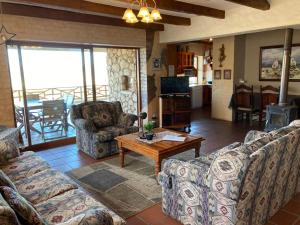 Sala de estar con sofás, mesa y TV en Kite View 2 Holiday Home, en Witsand