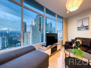 a living room with a couch and a tv at vortex suites klcc by LEAVA in Kuala Lumpur