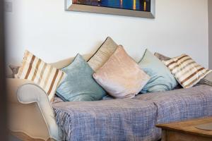 - un canapé avec un bouquet d'oreillers dans l'établissement 9A Millbrae - Donnini Apartments, à Ayr