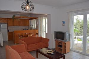 a living room with a couch and a tv at Corinthian Gulf View in Egira