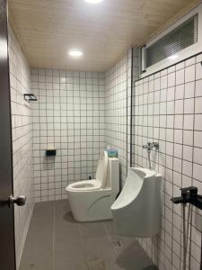a bathroom with a toilet and a urinal and a sink at Sailing Inn in Donggang +56 photos