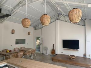 a living room with a flat screen tv and wicker pendant lights at Sailing Inn in Donggang