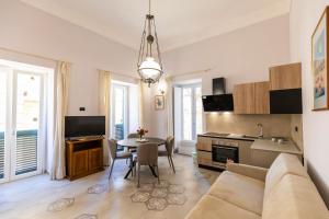 eine Küche und ein Wohnzimmer mit einem Sofa und einem Tisch in der Unterkunft Casa Vacanze Antico Sedile in Tropea